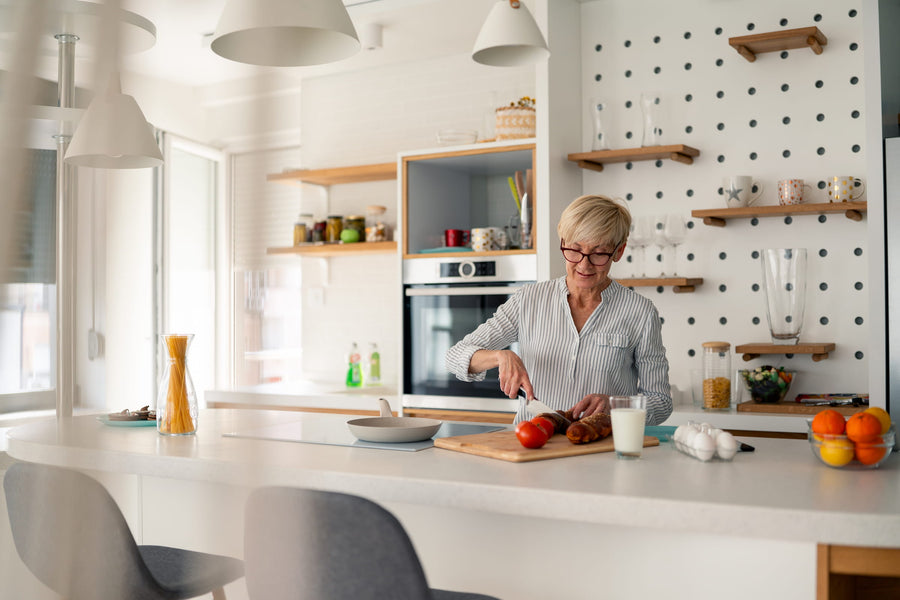 Middle-aged woman preparing a healthy meal in her kitchen — representative of adults in ZuvoMed's physician-guided GLP-1 weight management program.